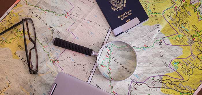 lupa y pasaporte sobre un mapa